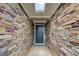 Inviting home entrance featuring a stone accent wall and a stylish, modern front door at 10892 Big Sky Dr, Hampton, GA 30228