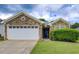 Charming single-story home featuring a stone facade, two-car garage, and well-manicured lawn at 10892 Big Sky Dr, Hampton, GA 30228