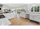 Open-concept kitchen featuring white cabinets, stainless steel appliances, and a view into the dining and living spaces at 1435 Willis Lake Nw Dr, Kennesaw, GA 30152