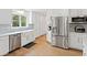Bright kitchen features stainless steel appliances, white cabinets, and a farmhouse sink at 1435 Willis Lake Nw Dr, Kennesaw, GA 30152