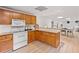 Well-lit kitchen features wooden cabinets, white appliances, and seamless access to the dining area at 1435 Willis Lake Nw Dr, Kennesaw, GA 30152
