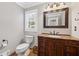 Powder room with granite countertop vanity and decorative mirror at 3331 Lockwood Sw Ct, Lilburn, GA 30047