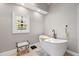 Bright bathroom featuring a soaking tub, stained glass window, and elegant decor at 3331 Lockwood Sw Ct, Lilburn, GA 30047