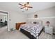 Cozy bedroom featuring a patterned quilt, ceiling fan, and natural light from the window at 3331 Lockwood Sw Ct, Lilburn, GA 30047