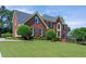 Classic brick home with meticulous landscaping showcasing a well-groomed lawn and mature trees, adding to its allure at 3331 Lockwood Sw Ct, Lilburn, GA 30047