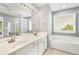 Bright bathroom with dual vanity, soaking tub, window, fan and tiled floor at 3471 Chastain Glen Ne Ln, Marietta, GA 30066