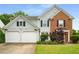 Charming two-story home featuring light blue siding, brick accents, a manicured lawn, and a two-car garage at 3471 Chastain Glen Ne Ln, Marietta, GA 30066