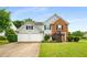 Charming two-story home featuring light blue siding, brick accents, a manicured lawn, and a two-car garage at 3471 Chastain Glen Ne Ln, Marietta, GA 30066