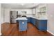 Well-lit kitchen boasts white countertops, stainless steel appliances, two-tone cabinetry and hardwood floors at 3471 Chastain Glen Ne Ln, Marietta, GA 30066