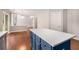 Kitchen island boasts white countertop and blue cabinets with an open view to the adjacent living area at 3471 Chastain Glen Ne Ln, Marietta, GA 30066