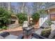 Cozy brick patio featuring a fireplace, outdoor seating, and lush greenery for relaxation at 45 Paces West Nw Dr, Atlanta, GA 30327
