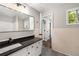 Bathroom featuring a large framed mirror, white cabinets, and black fixtures at 4701 Riverwood Cir, Decatur, GA 30035