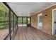 Enjoy the outdoors in this sunroom with brick accents and wood plank flooring at 4701 Riverwood Cir, Decatur, GA 30035