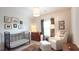 Bedroom with an elegant black crib, plush armchair, and neutral decor at 584 Bismark Ne Rd, Atlanta, GA 30324