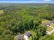 Aerial view of home surrounded by lush trees with large manicured yard and detached garage at 165 6Th St, Auburn, GA 30011