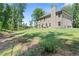 Large grassy backyard surrounded by mature trees offering a serene and private outdoor space at 165 6Th St, Auburn, GA 30011