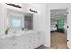 Bathroom with a double sink vanity, large mirror, and a view into the Primary bedroom at 165 6Th St, Auburn, GA 30011
