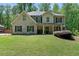 Charming two-story home featuring a covered front porch, well-manicured lawn, and beautiful landscaping at 165 6Th St, Auburn, GA 30011
