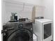 Convenient laundry room featuring modern washer and dryer, with overhead wire shelving at 165 6Th St, Auburn, GA 30011