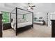 Spacious main bedroom with a four-poster bed, seating area, and views of the backyard at 165 6Th St, Auburn, GA 30011