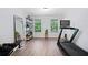 Bright workout room featuring a treadmill, weight bench, shelving unit and large mirror at 165 6Th St, Auburn, GA 30011
