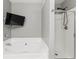 Bathroom features a soaking tub and a separate glass-enclosed shower with a mounted television at 1880 Garbrooke Cv, Lawrenceville, GA 30046