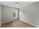 Bright bedroom with hardwood flooring, neutral paint, ceiling fan, and a window providing natural light at 1880 Garbrooke Cv, Lawrenceville, GA 30046