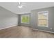Bedroom with neutral walls, ceiling fan and two windows allowing ample natural light at 1880 Garbrooke Cv, Lawrenceville, GA 30046