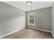 Bright bedroom with hardwood flooring, neutral paint, and a window providing natural light at 1880 Garbrooke Cv, Lawrenceville, GA 30046