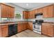 Well-lit kitchen features stainless steel appliances, wood cabinets, and a window over the sink at 1880 Garbrooke Cv, Lawrenceville, GA 30046