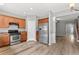 Open kitchen with stainless steel appliances and wood cabinets flows into the adjacent living area at 1880 Garbrooke Cv, Lawrenceville, GA 30046
