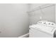 Laundry room with a white washing machine and a wire shelf for storage at 1880 Garbrooke Cv, Lawrenceville, GA 30046