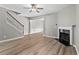 Bright living room with fireplace and wood-look floors, seamlessly connecting to other living areas at 1880 Garbrooke Cv, Lawrenceville, GA 30046