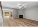 Bright living room with fireplace and wood-look floors, connecting seamlessly to the dining and kitchen areas at 1880 Garbrooke Cv, Lawrenceville, GA 30046