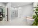 Bright bathroom featuring a glass shower, soaking tub, and white tile floor at 2020 Bixby Se St, Atlanta, GA 30317
