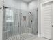 Modern bathroom shower with dual showerheads, stone pebble floor, and glass enclosure at 2020 Bixby Se St, Atlanta, GA 30317