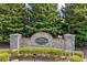 Stone sign for Little Suwanee Pointe, a Portrait Homes community, surrounded by lush greenery at 2331 Suwanee Pointe Dr, Lawrenceville, GA 30043