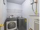 Modern laundry room with gray washer, dryer, white water heater and white wire shelf at 2331 Suwanee Pointe Dr, Lawrenceville, GA 30043
