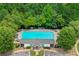 Aerial view of a large community pool with lounge chairs, tables, and a clubhouse surrounded by trees at 2331 Suwanee Pointe Dr, Lawrenceville, GA 30043
