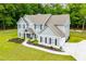 Aerial of a two-story home with long driveway, manicured landscaping, mature trees, and outdoor entertaining area at 445 Boulder Crest Trl, Villa Rica, GA 30180