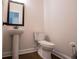 Powder room featuring pedestal sink, toilet, mirror, and base trim at 445 Boulder Crest Trl, Villa Rica, GA 30180