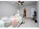 A bright, carpeted bedroom with a ceiling fan, neutral walls, and an adjacent bathroom at 445 Boulder Crest Trl, Villa Rica, GA 30180