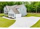 Gray two-story home featuring attached garage, long driveway, and lush landscaping at 445 Boulder Crest Trl, Villa Rica, GA 30180