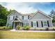 Two-story home showcasing well-manicured landscaping, dark shutters, a long driveway, and mature trees at 445 Boulder Crest Trl, Villa Rica, GA 30180