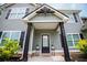 Beautiful front entrance with a covered porch, dark columns, and manicured landscaping at 445 Boulder Crest Trl, Villa Rica, GA 30180