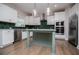Stylish kitchen features an island with sink, stainless steel appliances, green tile backsplash, and modern lighting at 445 Boulder Crest Trl, Villa Rica, GA 30180