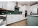 Modern kitchen featuring an island, white cabinetry, stainless steel appliances and a dark green backsplash at 445 Boulder Crest Trl, Villa Rica, GA 30180