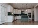 Modern kitchen with white cabinets, stainless steel appliances, green tile backsplash, and island with pendant lighting at 445 Boulder Crest Trl, Villa Rica, GA 30180