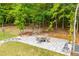 Patio seating area with an outdoor dining set and a fire pit, framed by natural landscaping at 445 Boulder Crest Trl, Villa Rica, GA 30180
