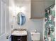 Updated bathroom features modern vanity, decorative mirror, and tiled shower with stylish shower curtain at 447 Wallace Way, Rockmart, GA 30153